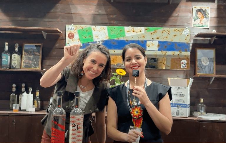 Two women smiling at a tequila booth