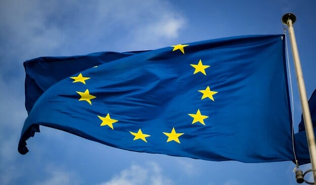 European Union flag waving in the sky.
