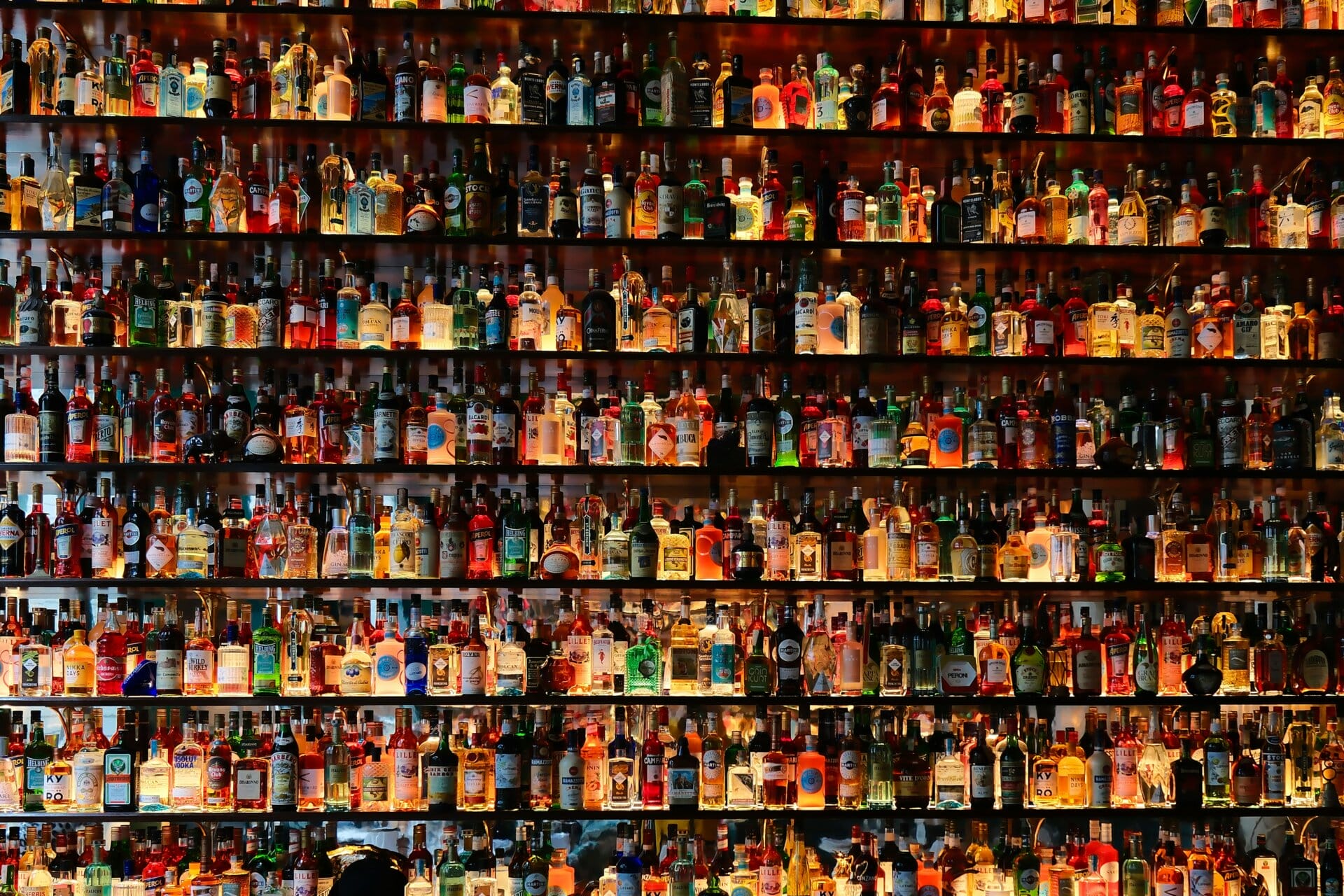 Colorful liquor bottles on shelves in a bar