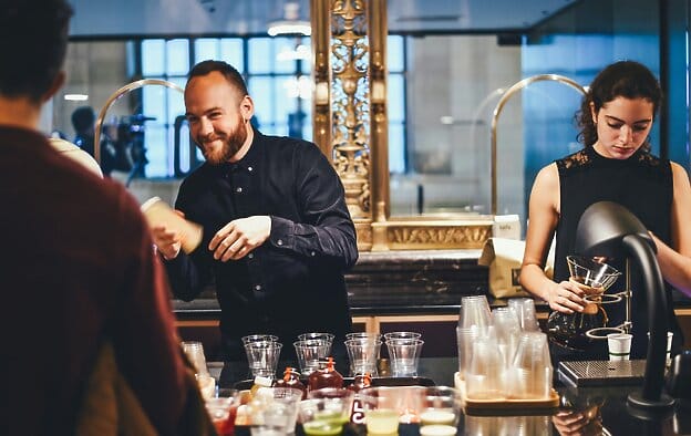 Baristas making drinks behind a counter.