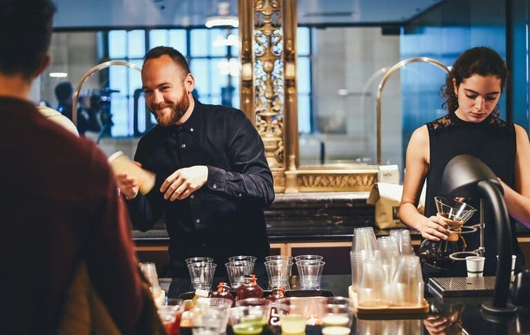 Baristas making drinks behind a counter.