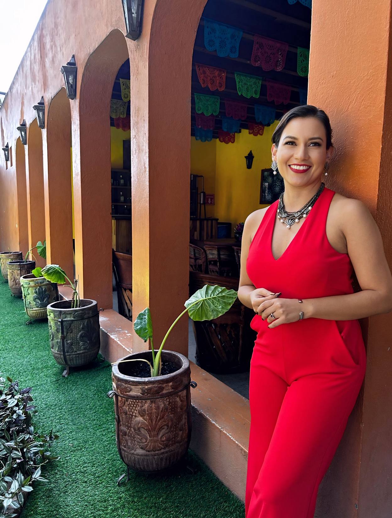 Smiling woman in red outfit by colorful patio