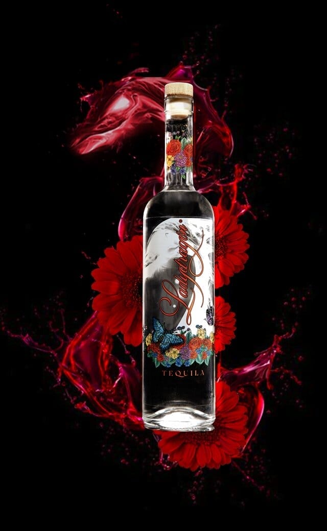 Decoratieve tequilafles met rode bloemen en spetter.