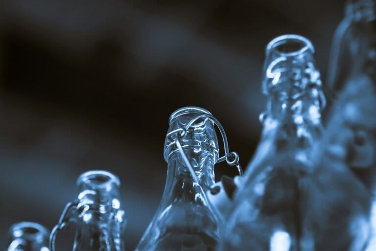 Close-up of glass bottles with metal clips.